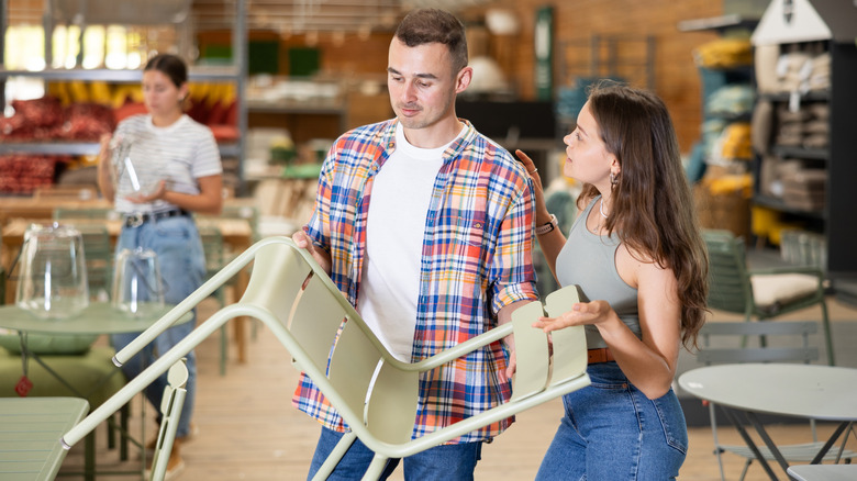 young couple furniture shopping for paneled patio chair