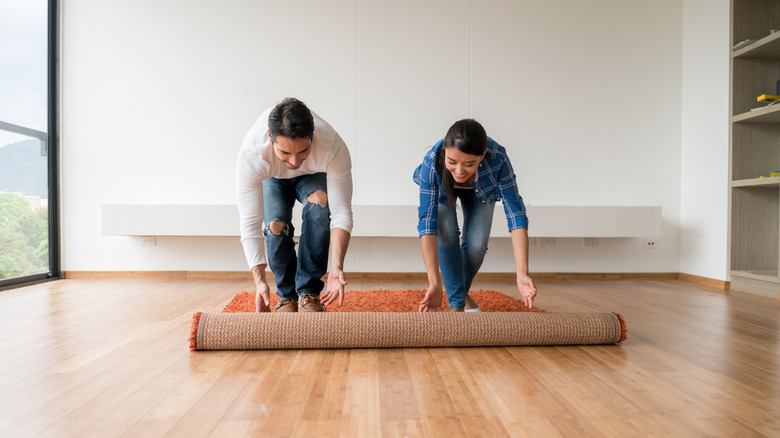 Couple unrolling rug