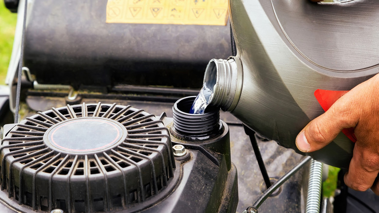 Man pours gasoline into mower