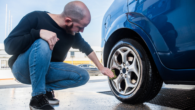 Man wiping car wheels