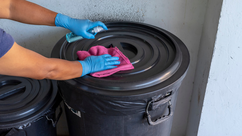 Person cleaning trash can