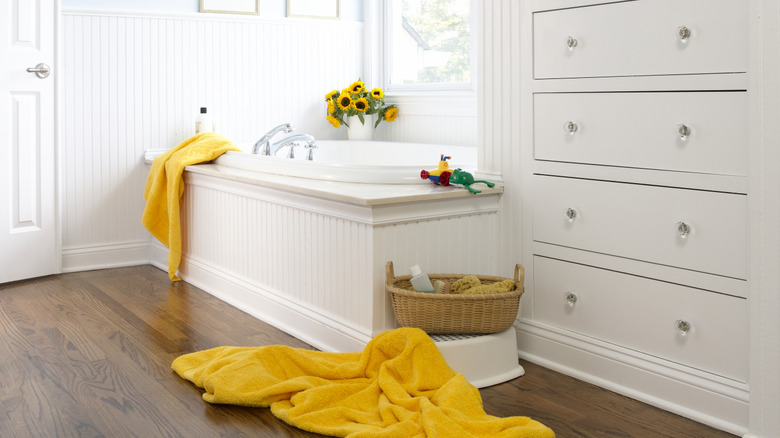 set of drawers in bathroom with towel and toy