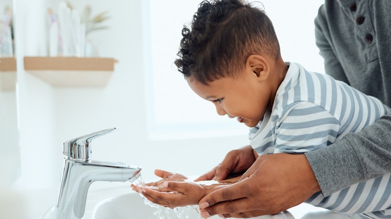 Boy washing hands in bathroom