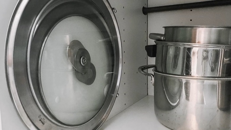 Pots and lids in cabinet