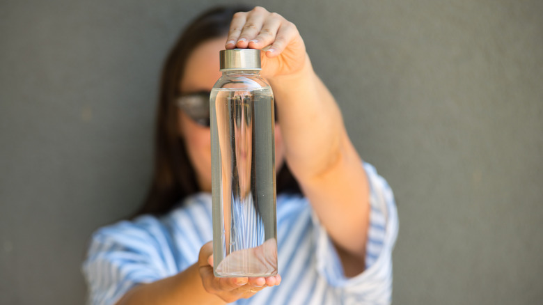 Woman holding a plastic water bottle