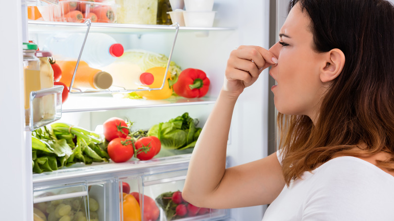 woman opening smelly fridge