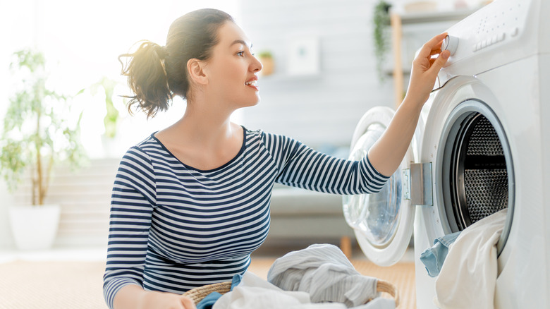 Woman choosing setting on washer