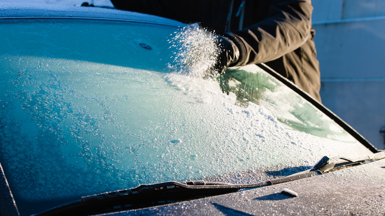 A man cleaning frozen windshield 