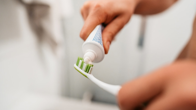 An individual squeezes out toothpaste