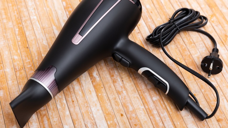 A hairdryer on a wood table.