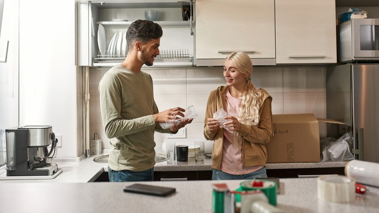 couple packing kitchen to move