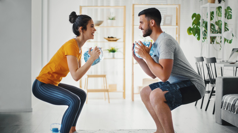 couple holding weighted plastic bottles