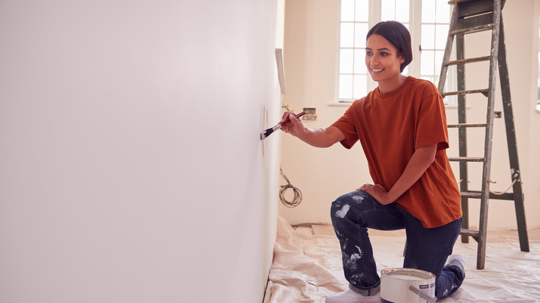 Woman looking at test patch on white wall