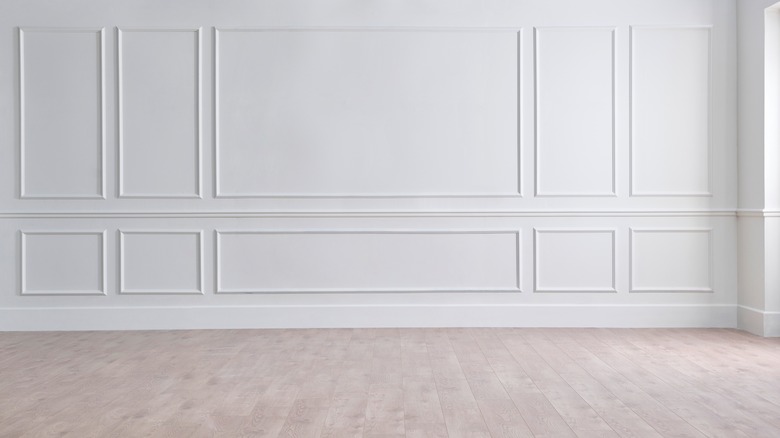 White wall with picture molding and hardwood flooring 