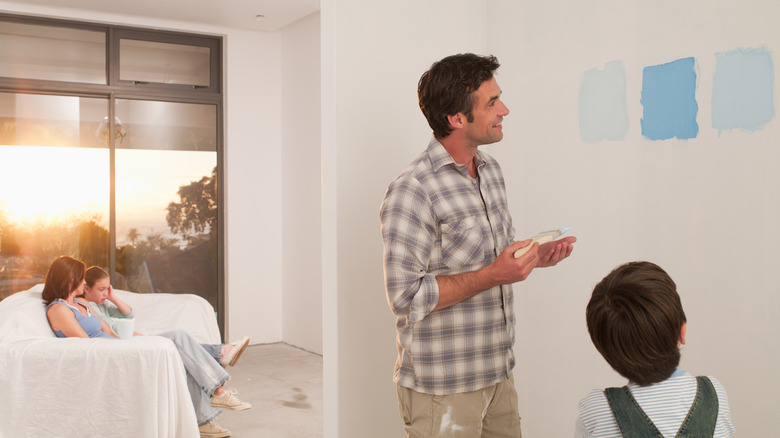 Father and son looking at large paint swatches on the wall