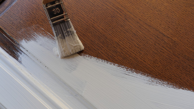 Brown kitchen cabinet being painted white