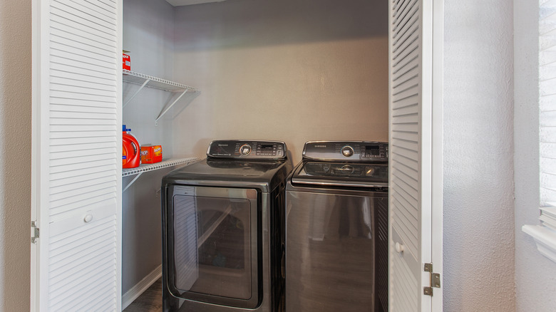 dark grey washer and dryer in a small laundry room closet