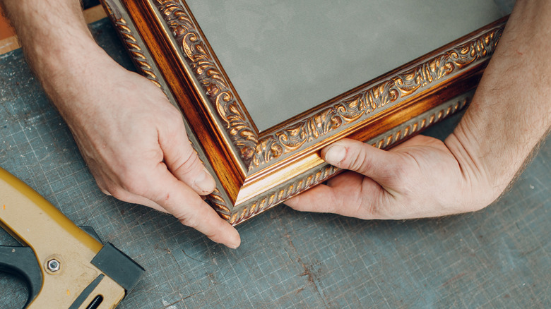 Man taking off back of picture frame