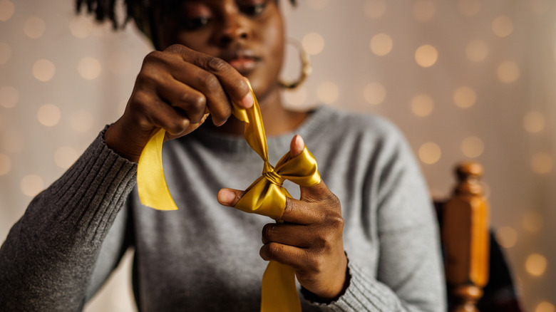 woman making bow out of ribbon