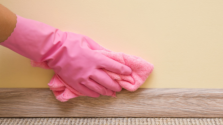 wiping wall clean with cloth