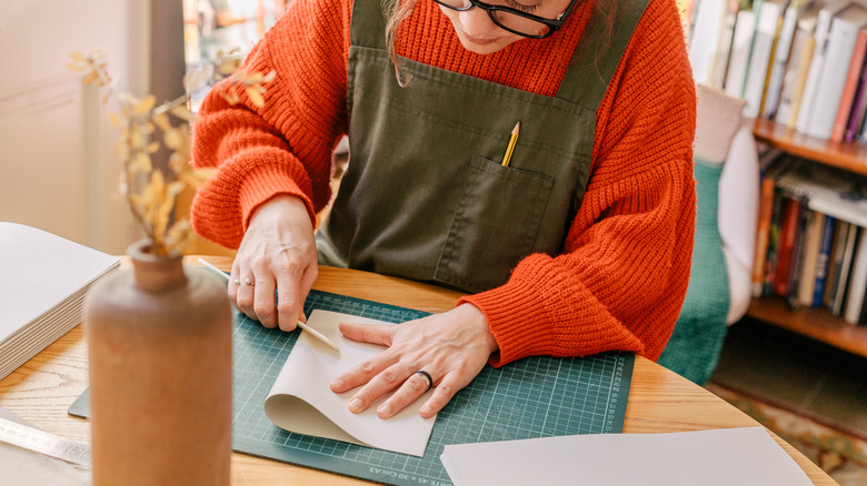 Woman cutting construction paper