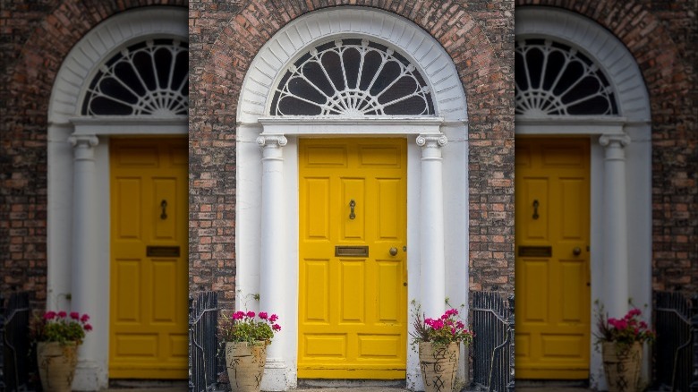 yellow door with white pillars