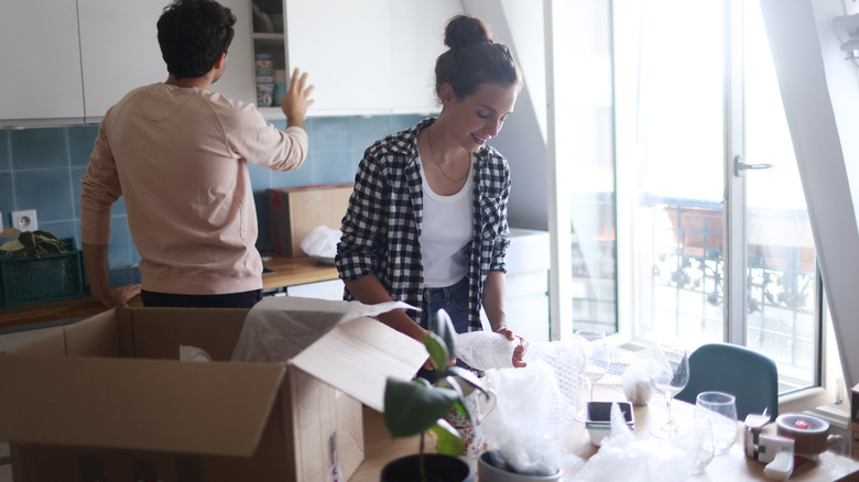 woman packing away sentimental dishware in bubble wrap