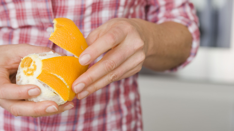 woman peeling an orange