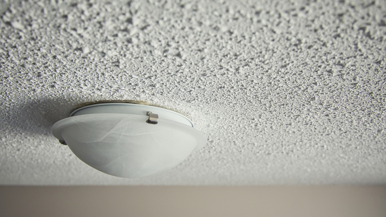 Old-fashioned white popcorn ceiling with a ceiling light