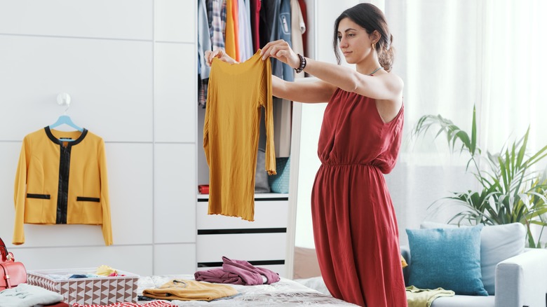 person organizing clothes beside closet