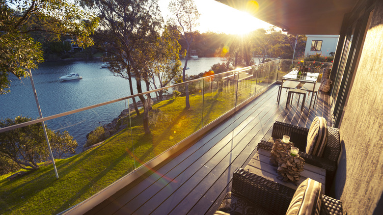 The balcony of a house that overlooks a coastal inlet with boats.