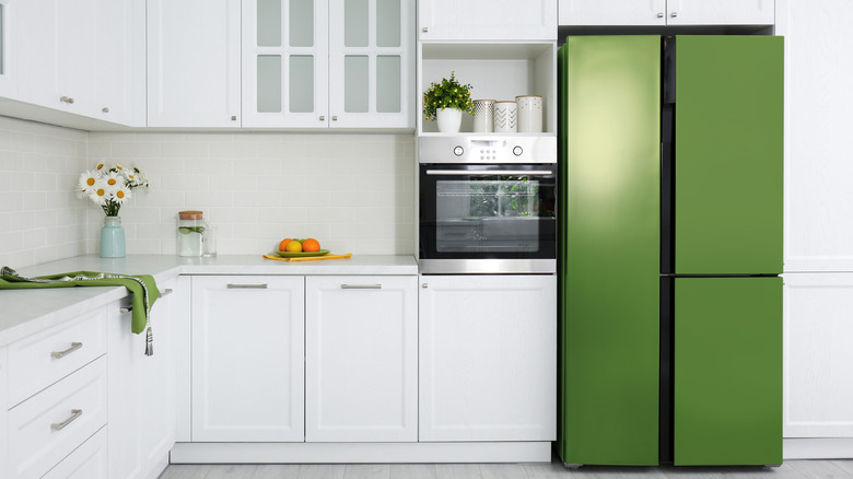 A kitchen fridge covered in green contact paper