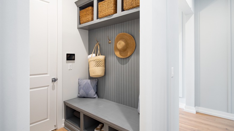 Newly built entryway mudroom with organizer baskets and a throw pillow