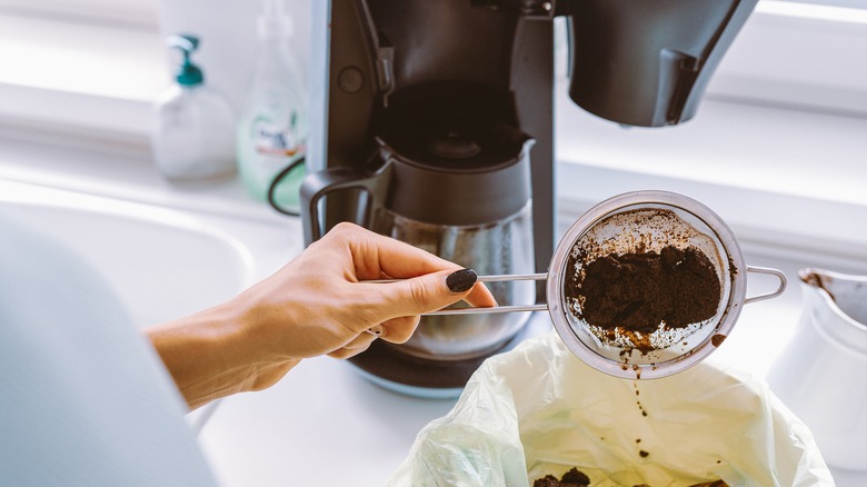 Hand with coffee grounds in strainer