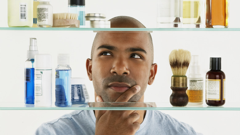 man surveying bathroom medicine cabinet