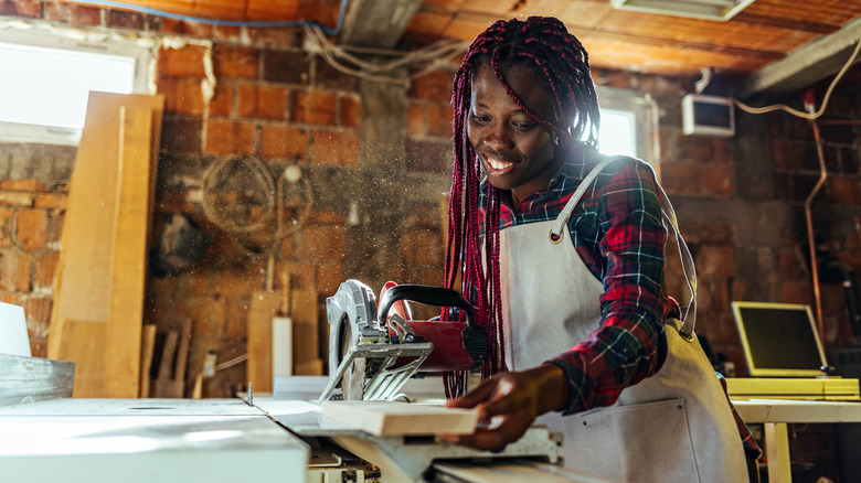 person cutting wood power saw