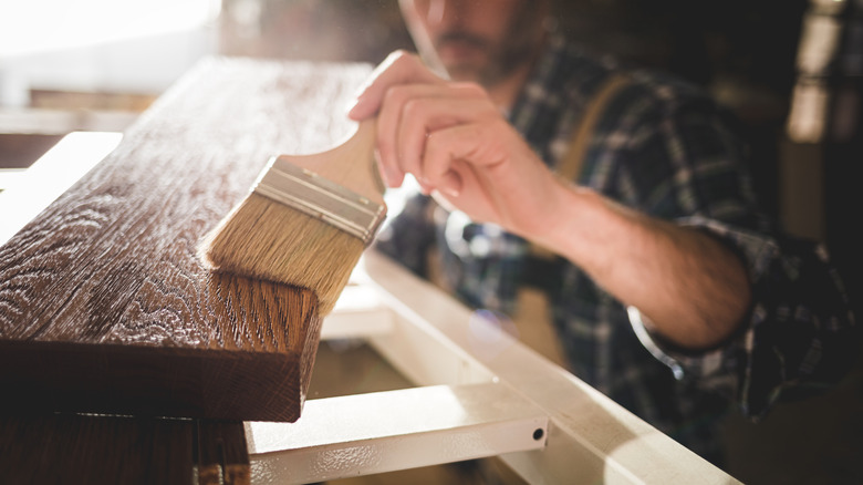 man brushing on wood