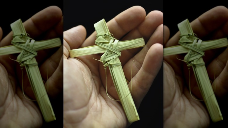 Small cross woven out of palm leaves in someone's hand