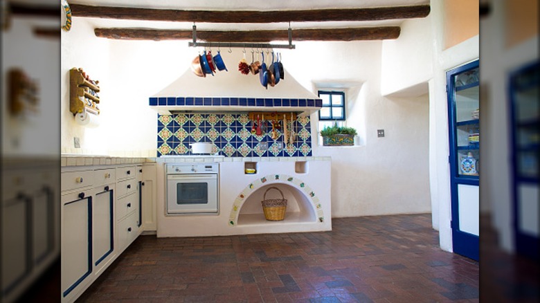 A kitchen has a modern brick floor