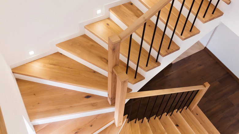 Spiral wood staircase with white walls