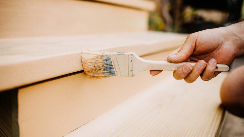 Person painting stairs with white paint