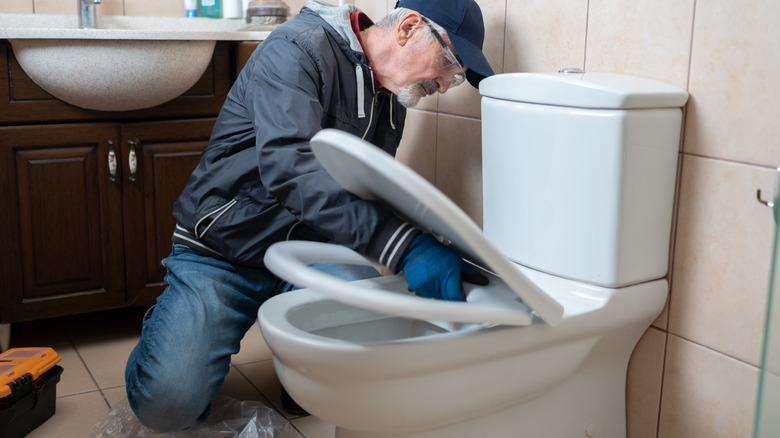 man installing a toilet