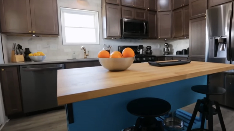 blue kitchen island with dark cabinets