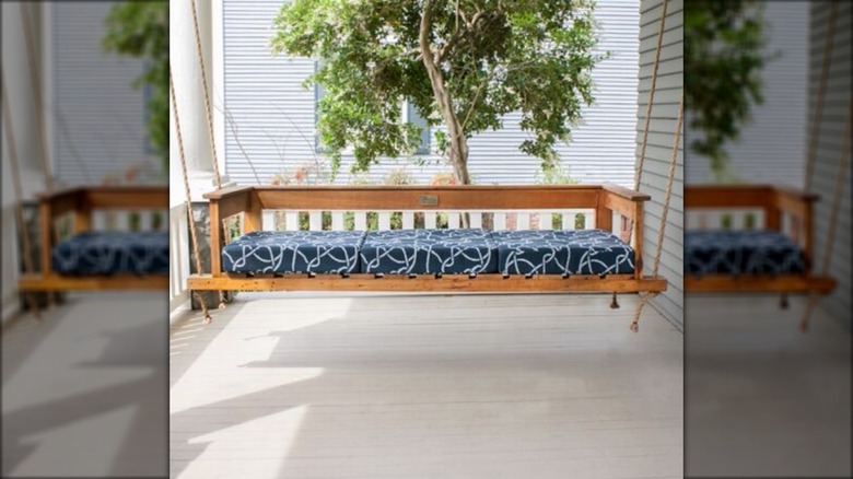 Porch swing with blue cushion