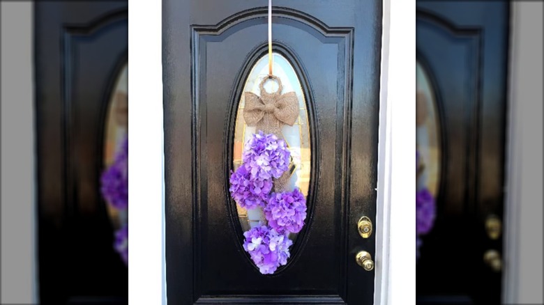 Purple flowers hanging on a black door