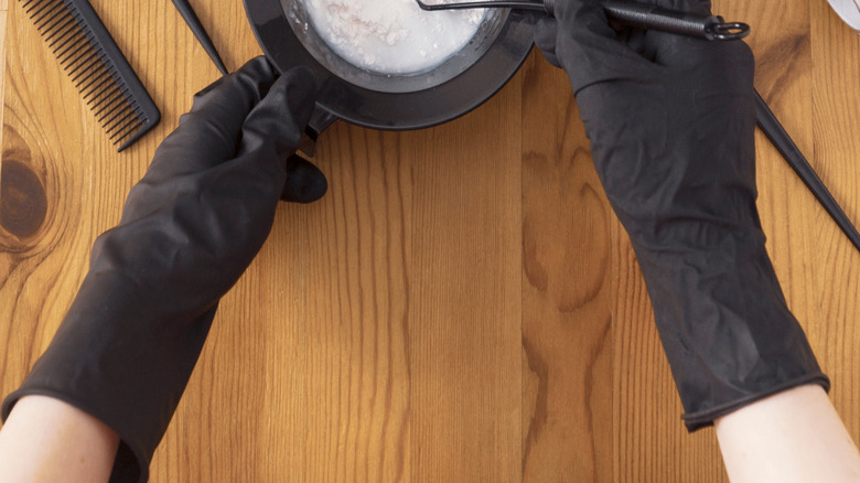 Materials to apply hair dye on a wooden surface