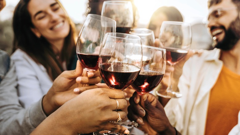 people clinking wine glasses