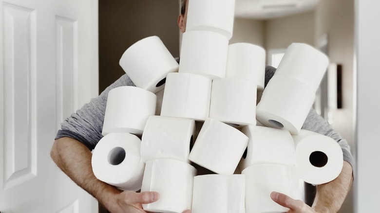 Man holding so much toilet paper that his face isn't visible