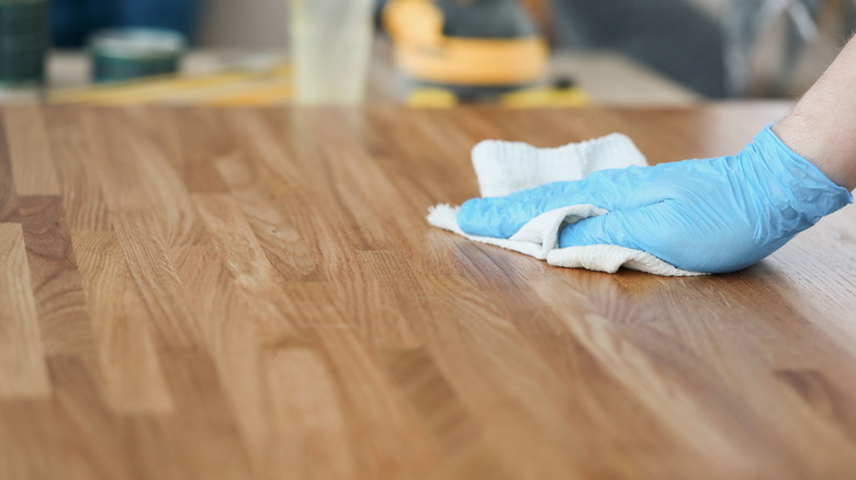 Hand wiping wooden table