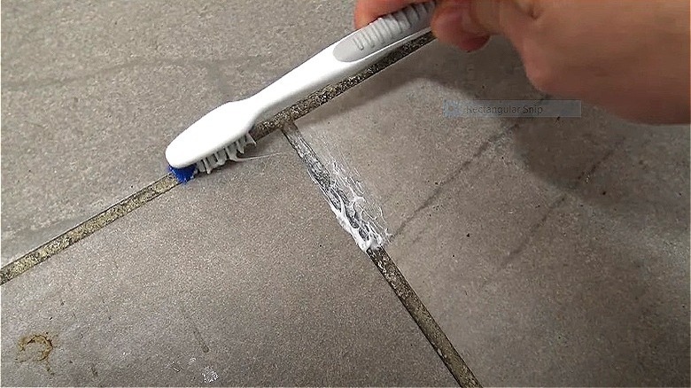 applying toothpaste on tile grout